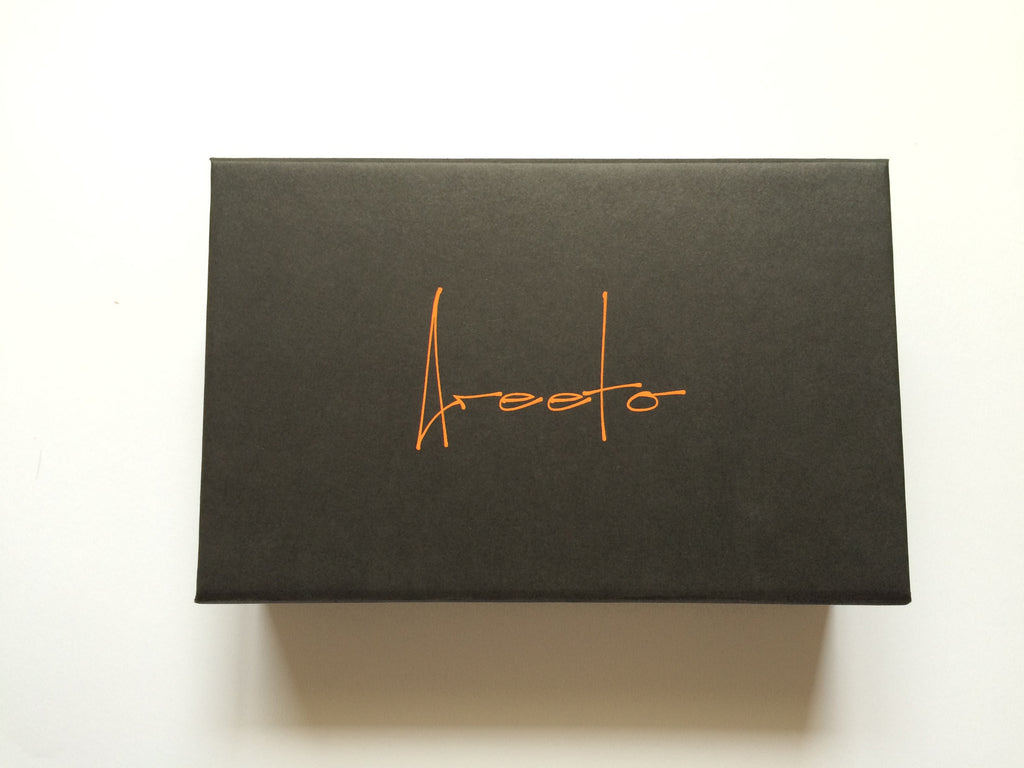 Exclusive invitation card in black and orange, cushioned box.