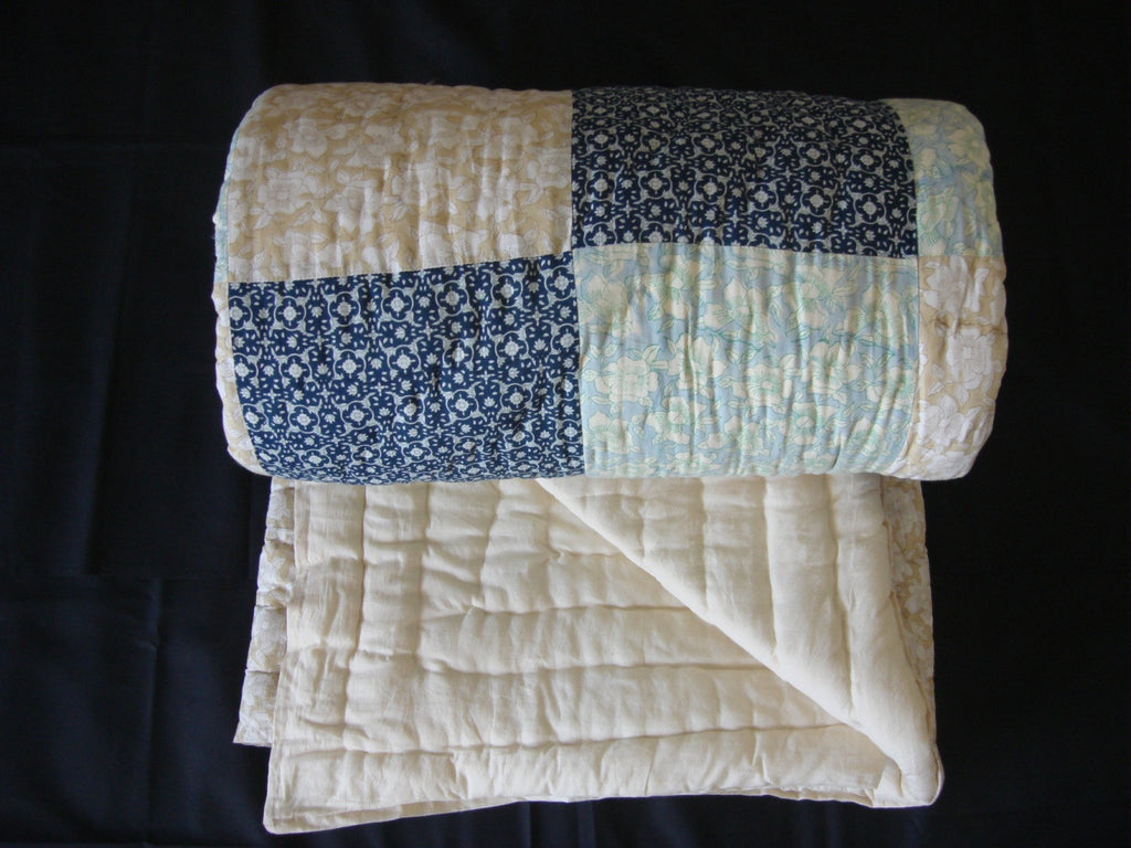 Handmade, patchwork cotton quilt in sequentially placed blocks with black designs on the reverse side