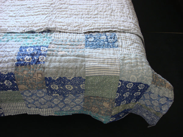 Handmade, patchwork cotton quilt in shades of grey, green and blue