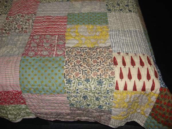 Handmade, patchwork cotton quilt in floral pattern blended with stripes.