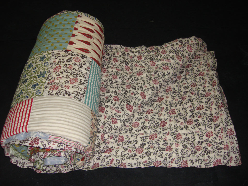 Handmade, patchwork cotton quilt in floral pattern blended with stripes.